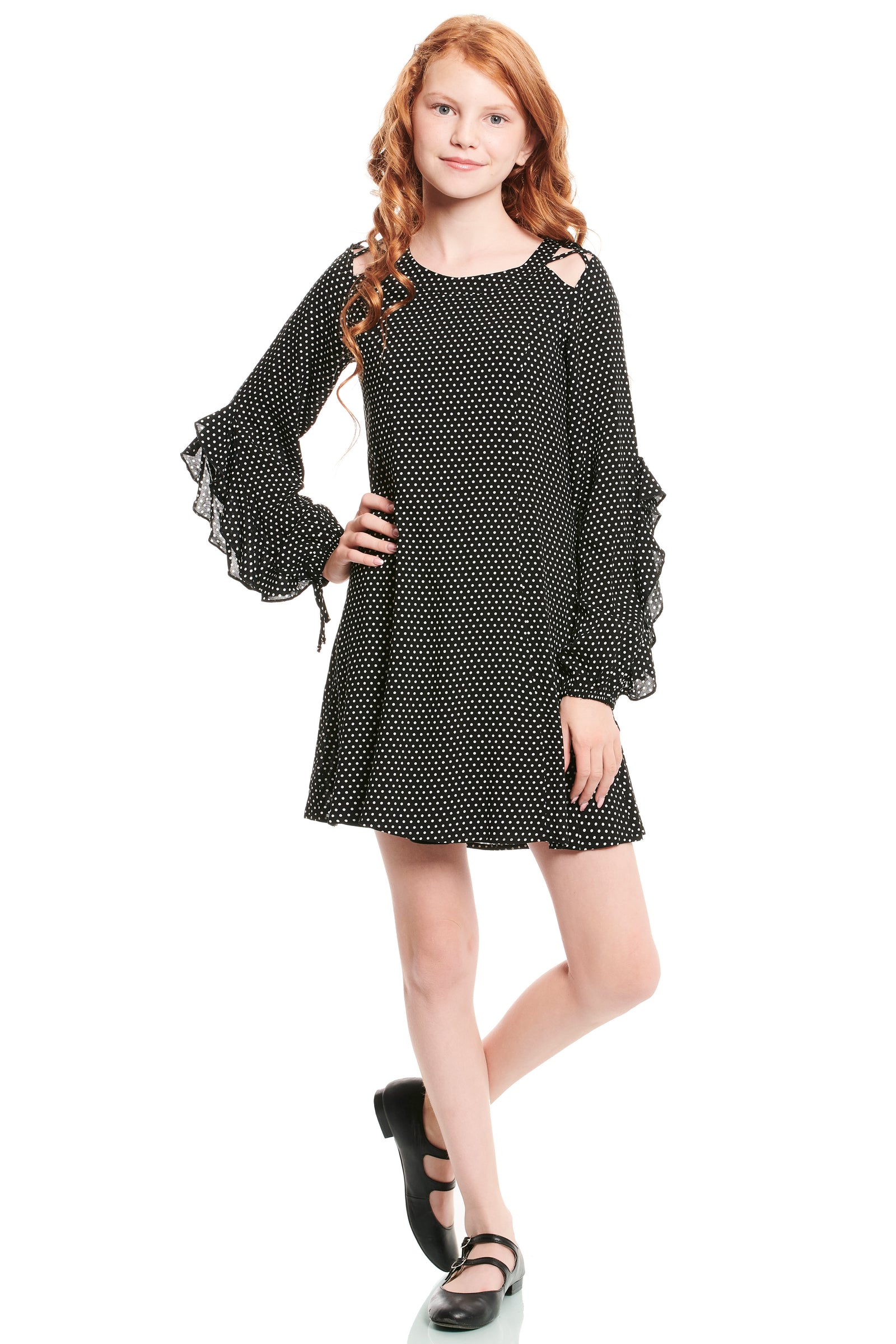 Young girl wearing a black polka dot dress on a white background