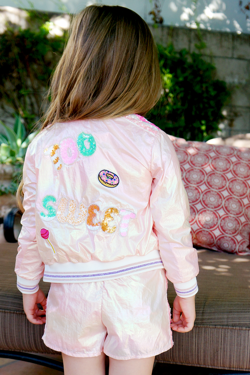 My Hannah Banana Little Girl’s Iridescent Sequin Patch Sporty Shorts.  Colorful Heather Metallic Full Elastic Waistline Sporty Sequin Multi Color Striped Sides Pink Iridescent Rainbow Shimmer Material  Fun Playful Donut & Lollipop Patch Embellishments  Imported