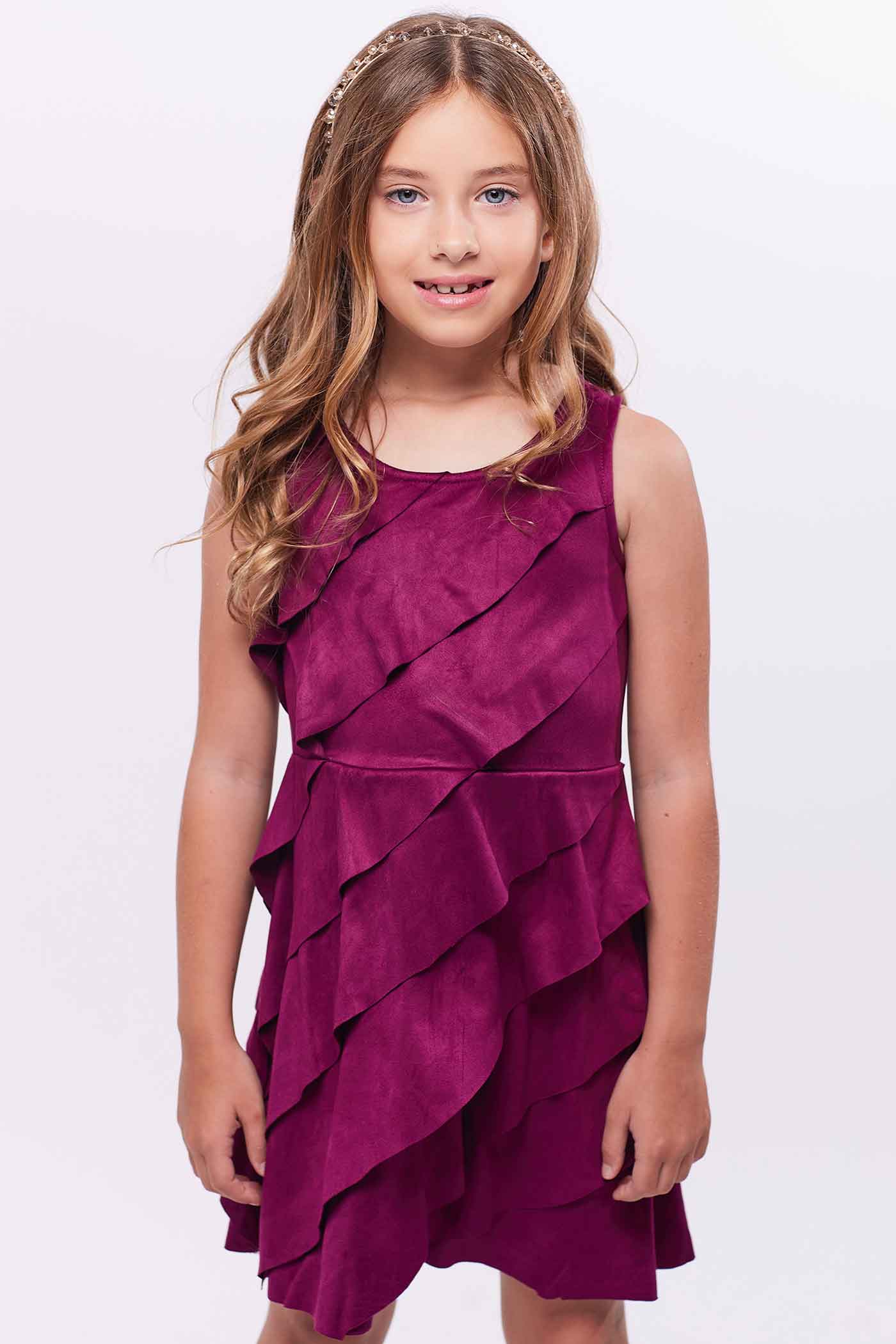 Girls Asymmetrical Ruffle Tiered Sleeveless Suede Dress Round neck Stylish asymmetrical ruffle highlighted design Back zipper closure Fancy faux suede fabrication Right above the knee length Perfect dress for fall or winter holiday festivities.  Imported