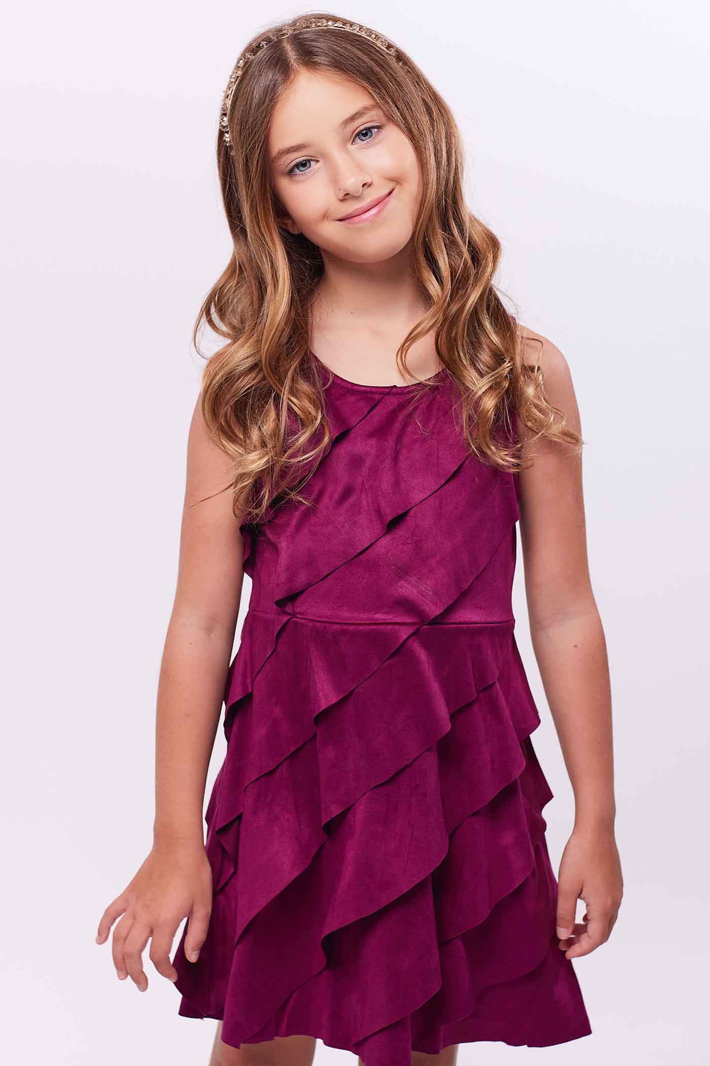 Girls Asymmetrical Ruffle Tiered Sleeveless Suede Dress Round neck Stylish asymmetrical ruffle highlighted design Back zipper closure Fancy faux suede fabrication Right above the knee length Perfect dress for fall or winter holiday festivities.  Imported