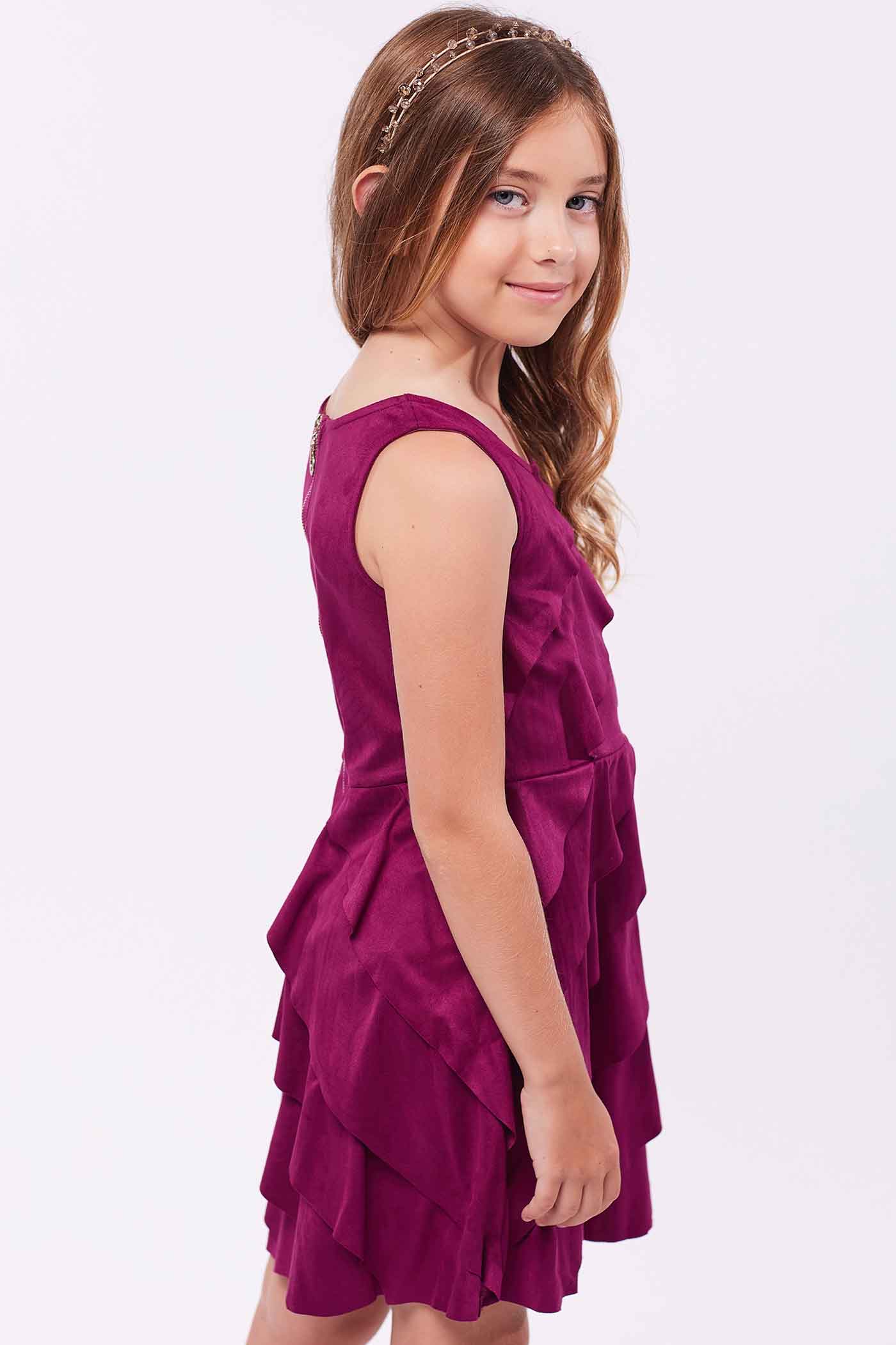 Girls Asymmetrical Ruffle Tiered Sleeveless Suede Dress Round neck Stylish asymmetrical ruffle highlighted design Back zipper closure Fancy faux suede fabrication Right above the knee length Perfect dress for fall or winter holiday festivities.  Imported